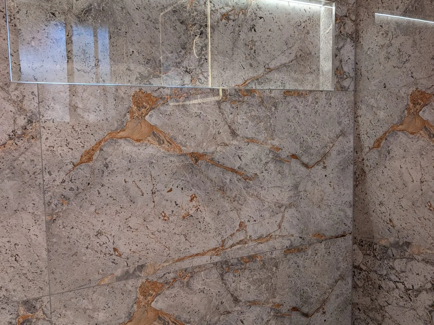 Quakers Hill family bathroom toilet with veined stone-look tiling