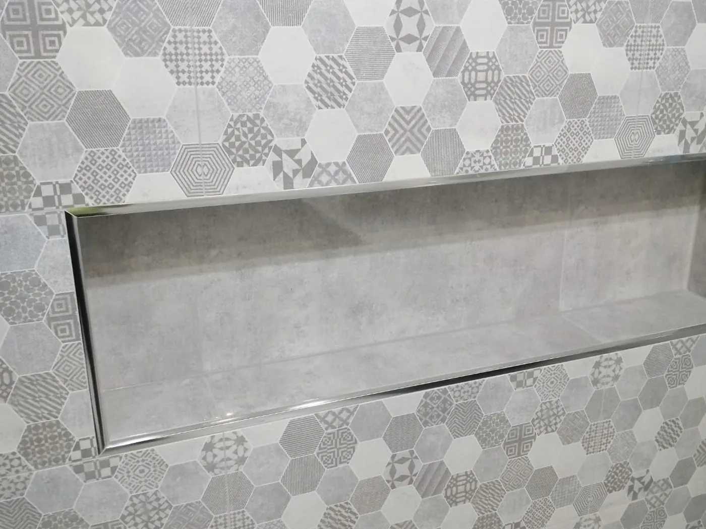 Minto renovation lit shower niche with hexagon mosaic surround