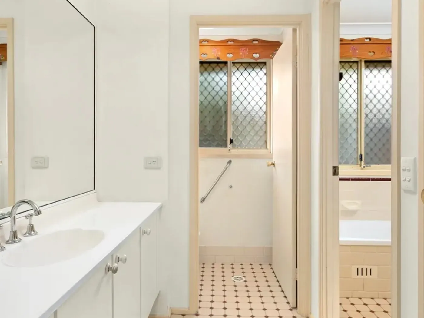 Woodcroft bathroom before renovation with dated cream tiles and old vanity