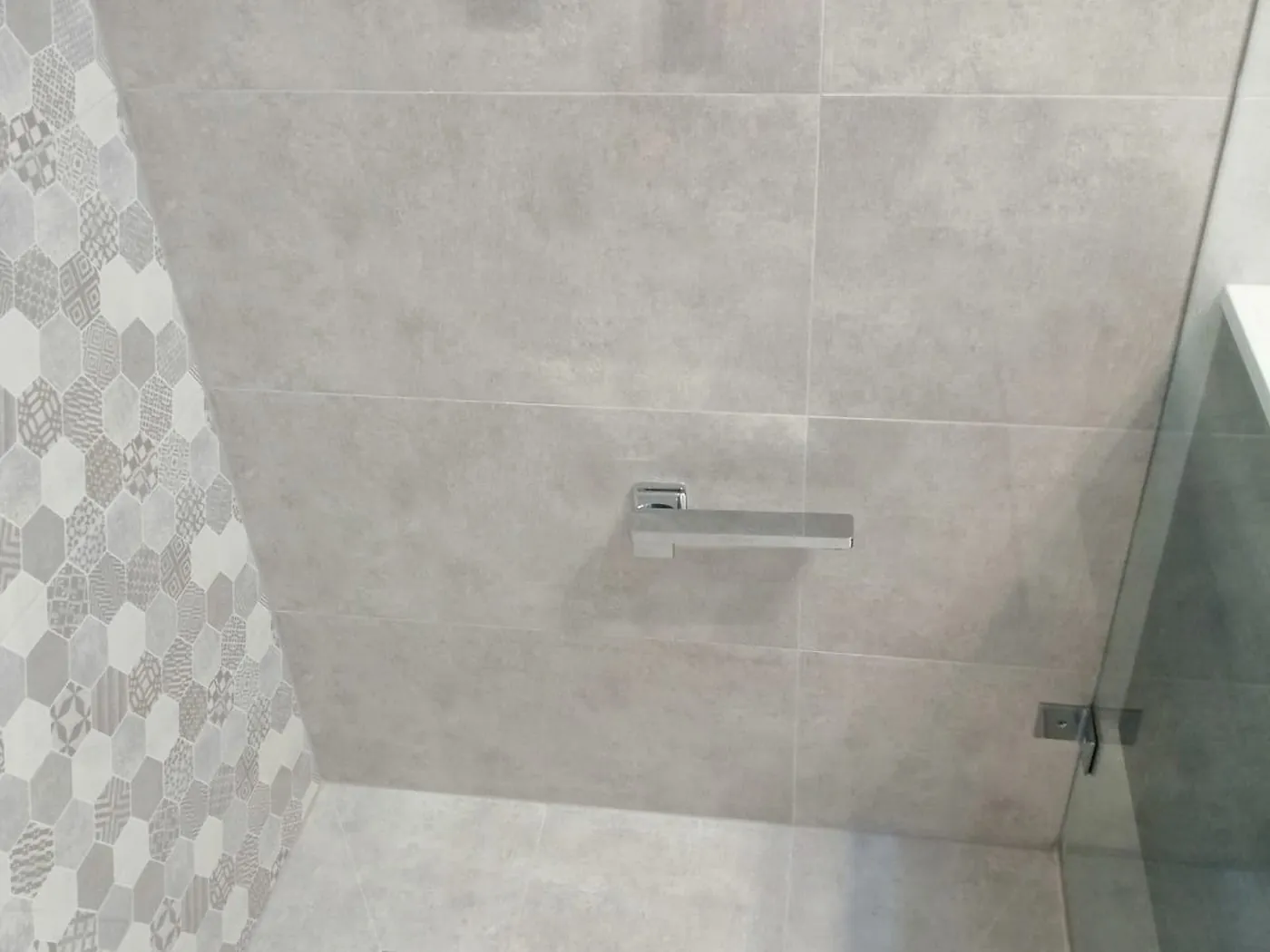 Minto bathroom after renovation with hobless walk-in shower and hexagon feature tiling