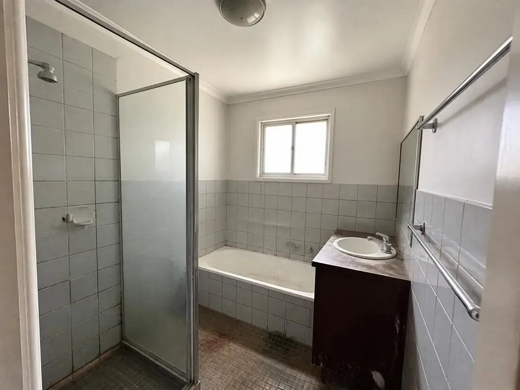 Older Western Sydney bathroom before renovation showing dated tiles and a failing shower base