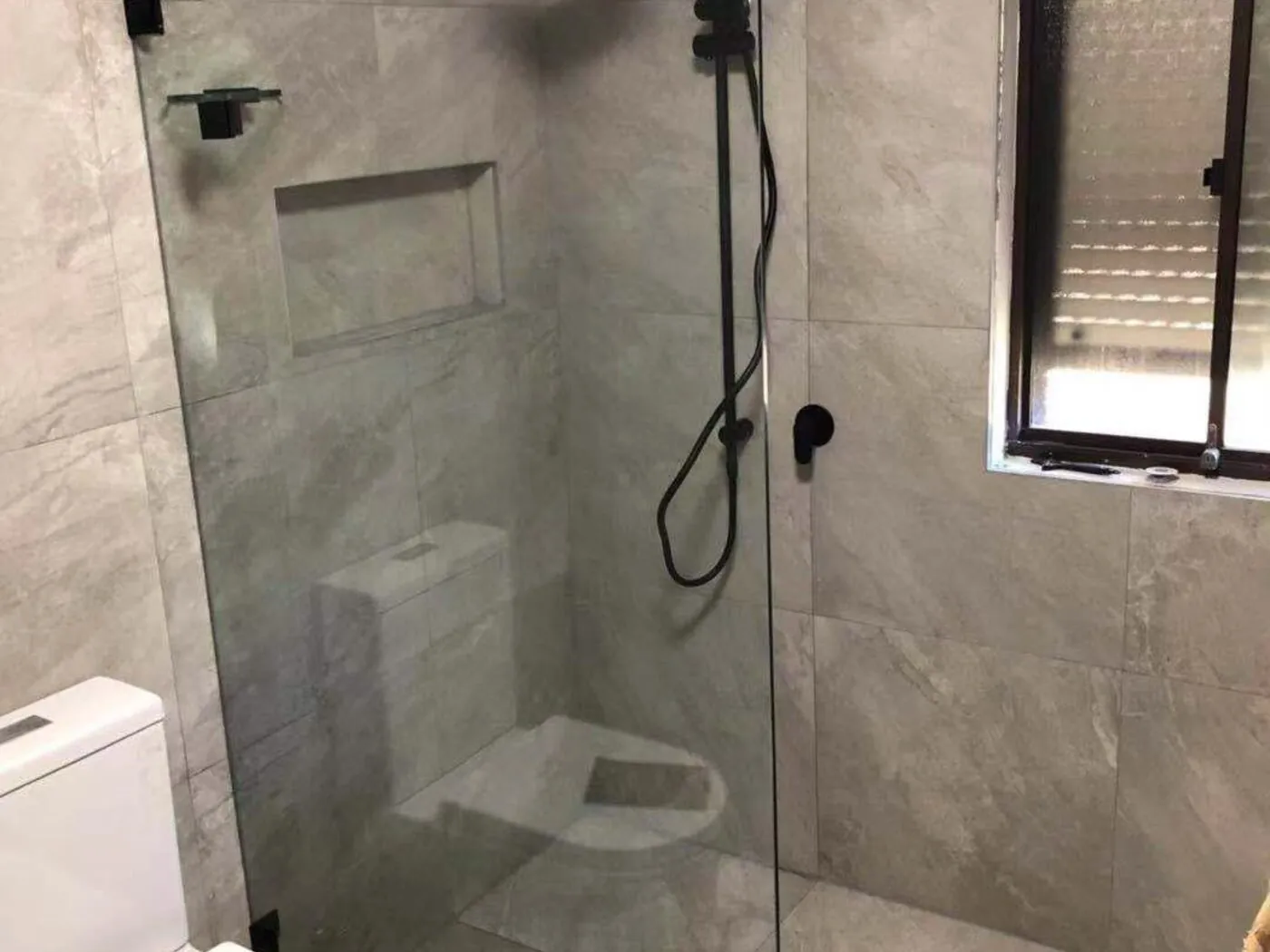 Blacktown bathroom renovation with frameless glass shower, matte black tapware and stone-look tiles