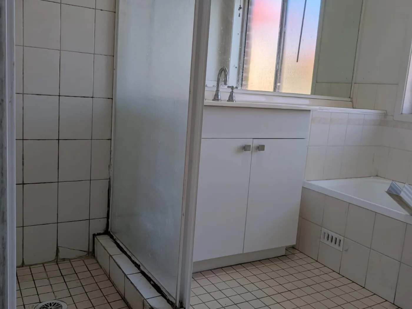 Quakers Hill bathroom before renovation with old tiled shower and small square floor tiles