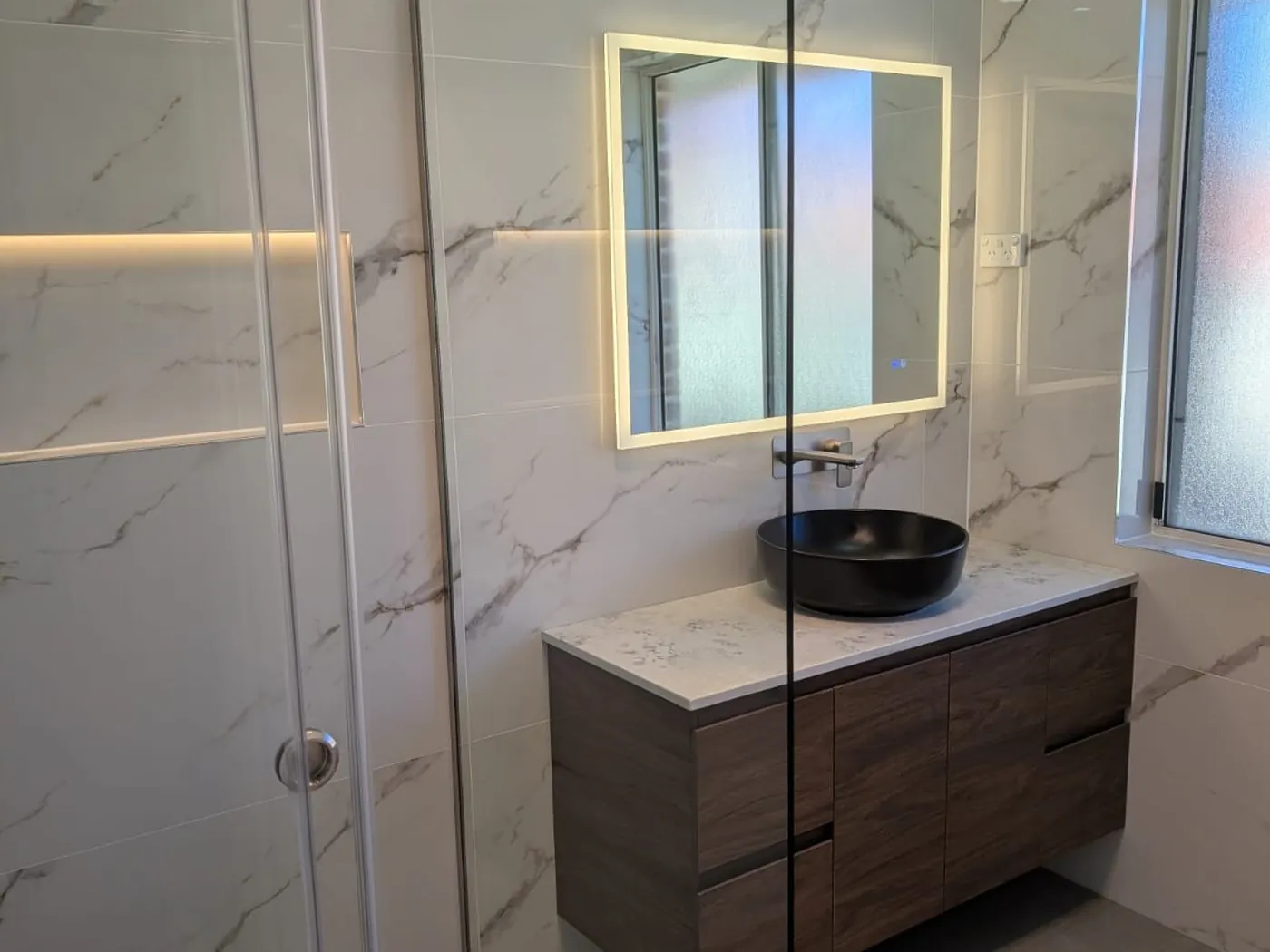 Quakers Hill renovation vanity with black vessel basin and backlit mirror