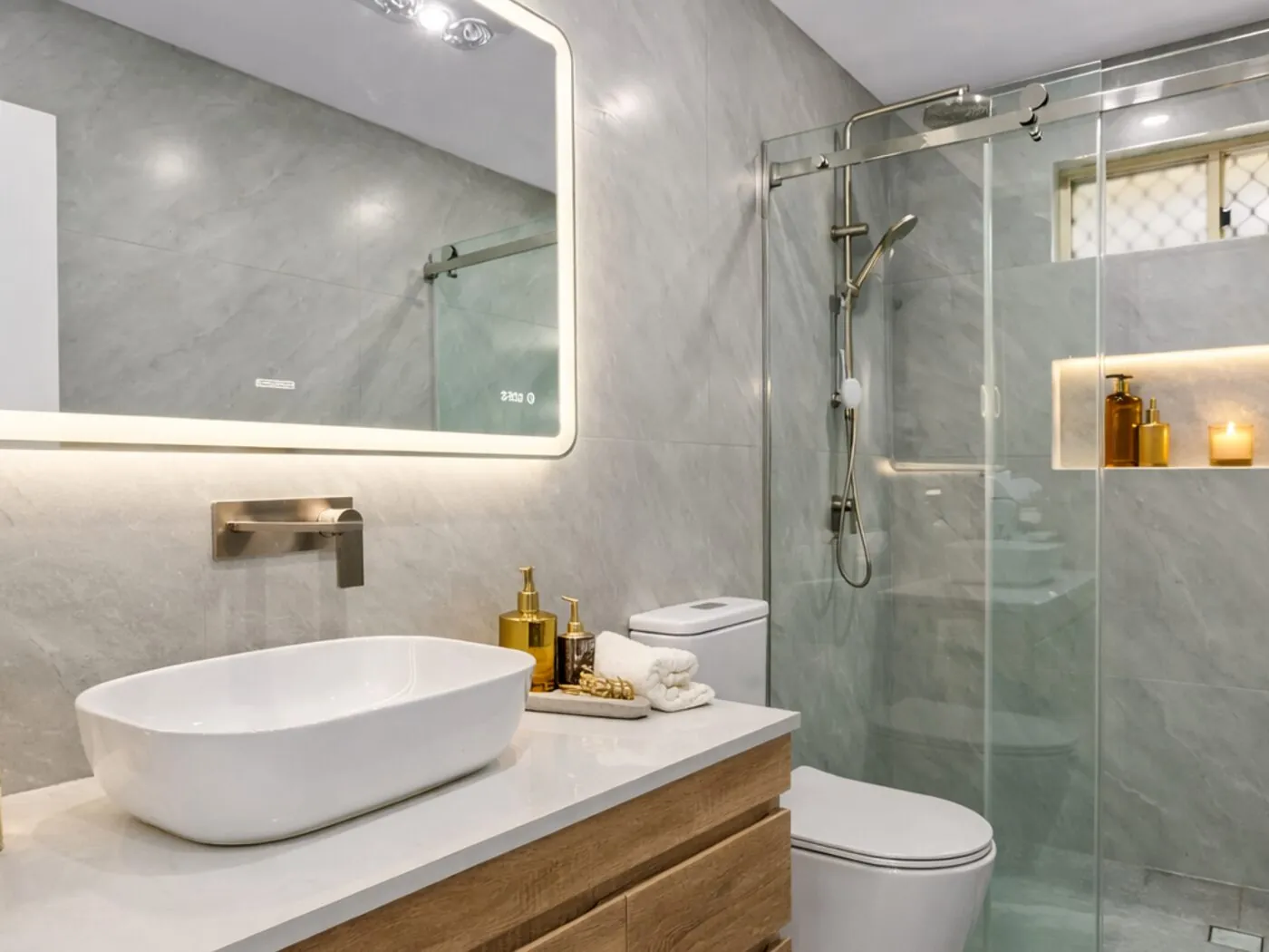Completed Woodcroft bathroom renovation with stone-look tiling, timber vanity and backlit mirror